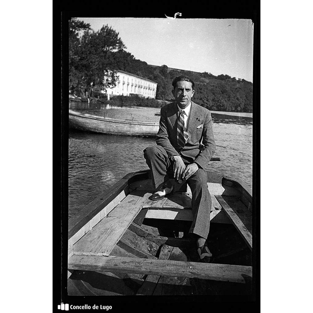 Retrato de Julio Veloso sentado nunha barca nas proximidades do Balneario de Lugo