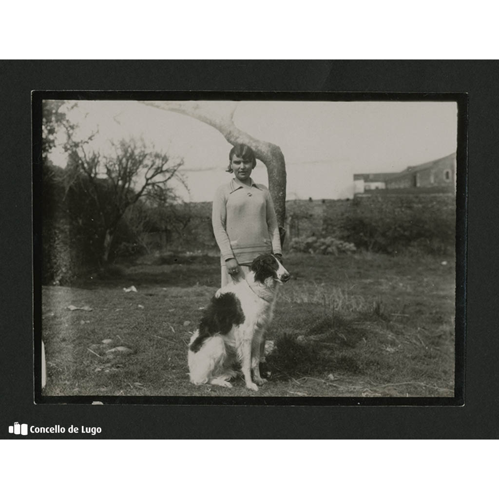 Retrato dunha muller cun can sentada nun campo