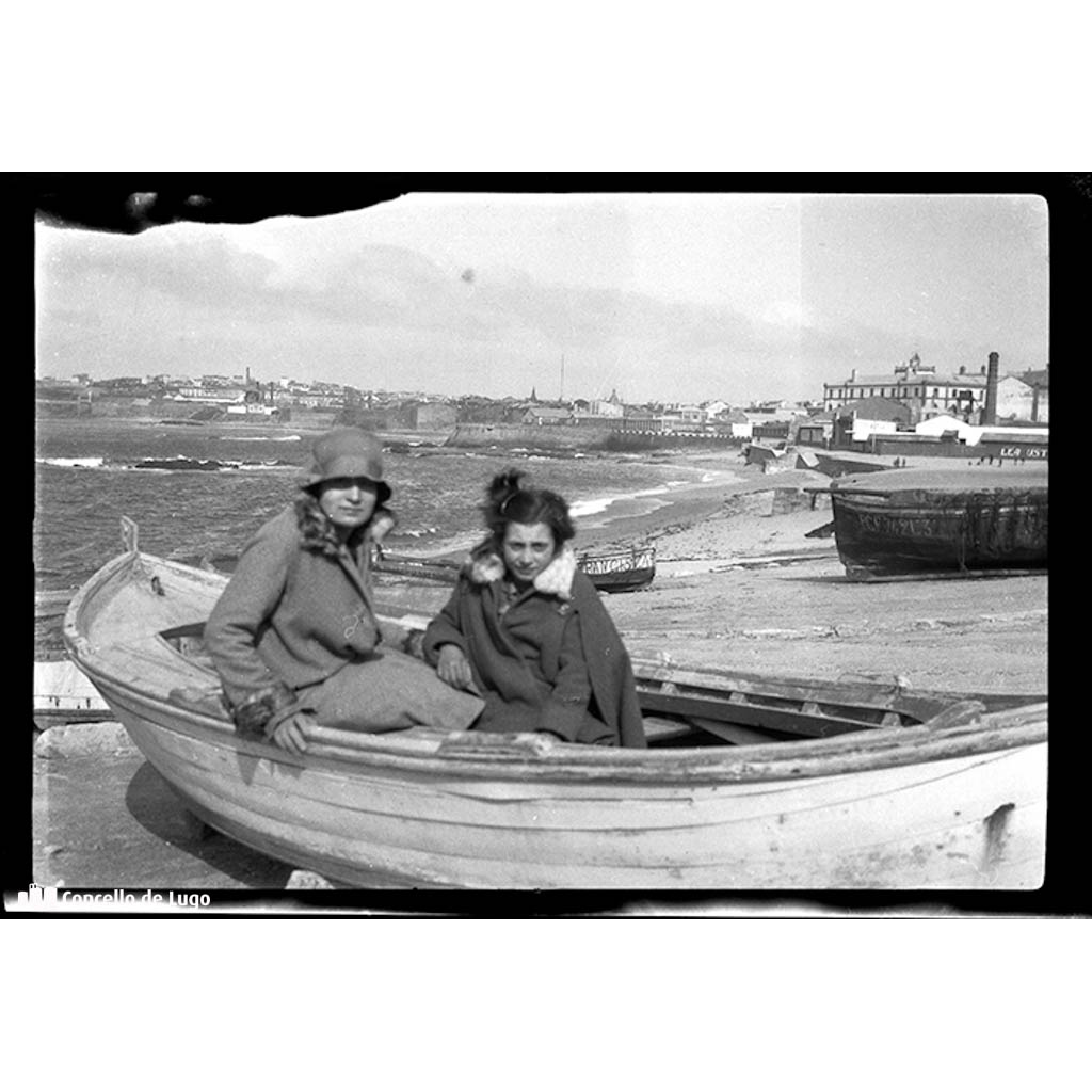 Retrato de dúas mulleres nunha barca na praia. A Coruña